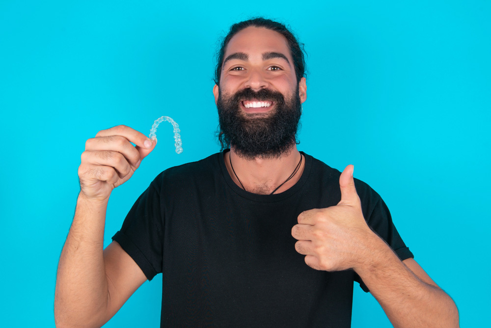 man with full beard celebrating his clear aligners